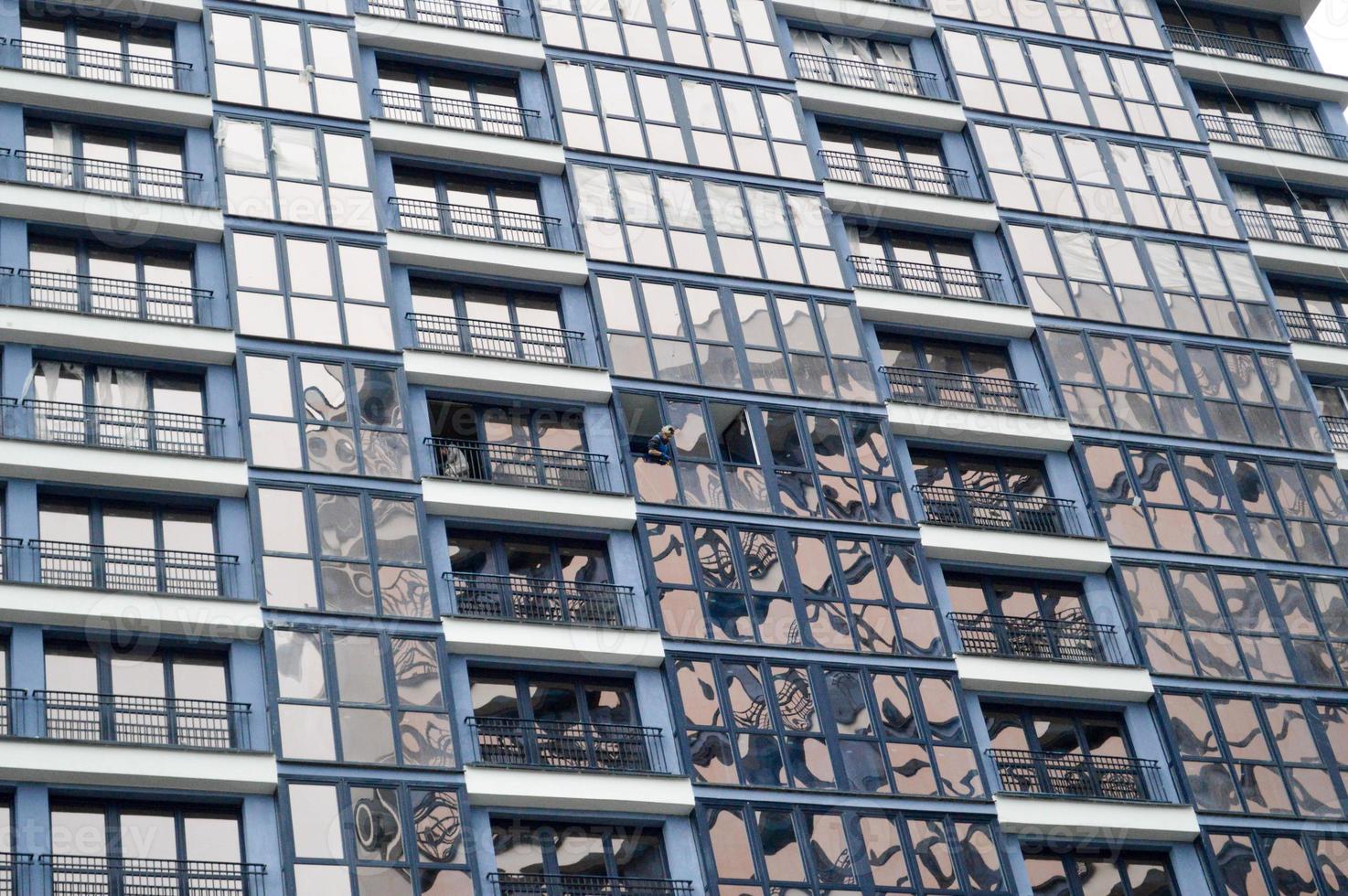 bellissimo moderno blu bicchiere fibra di vetro finestre di il facciata parete di un' moderno grattacielo edificio Casa. sfondo, struttura foto