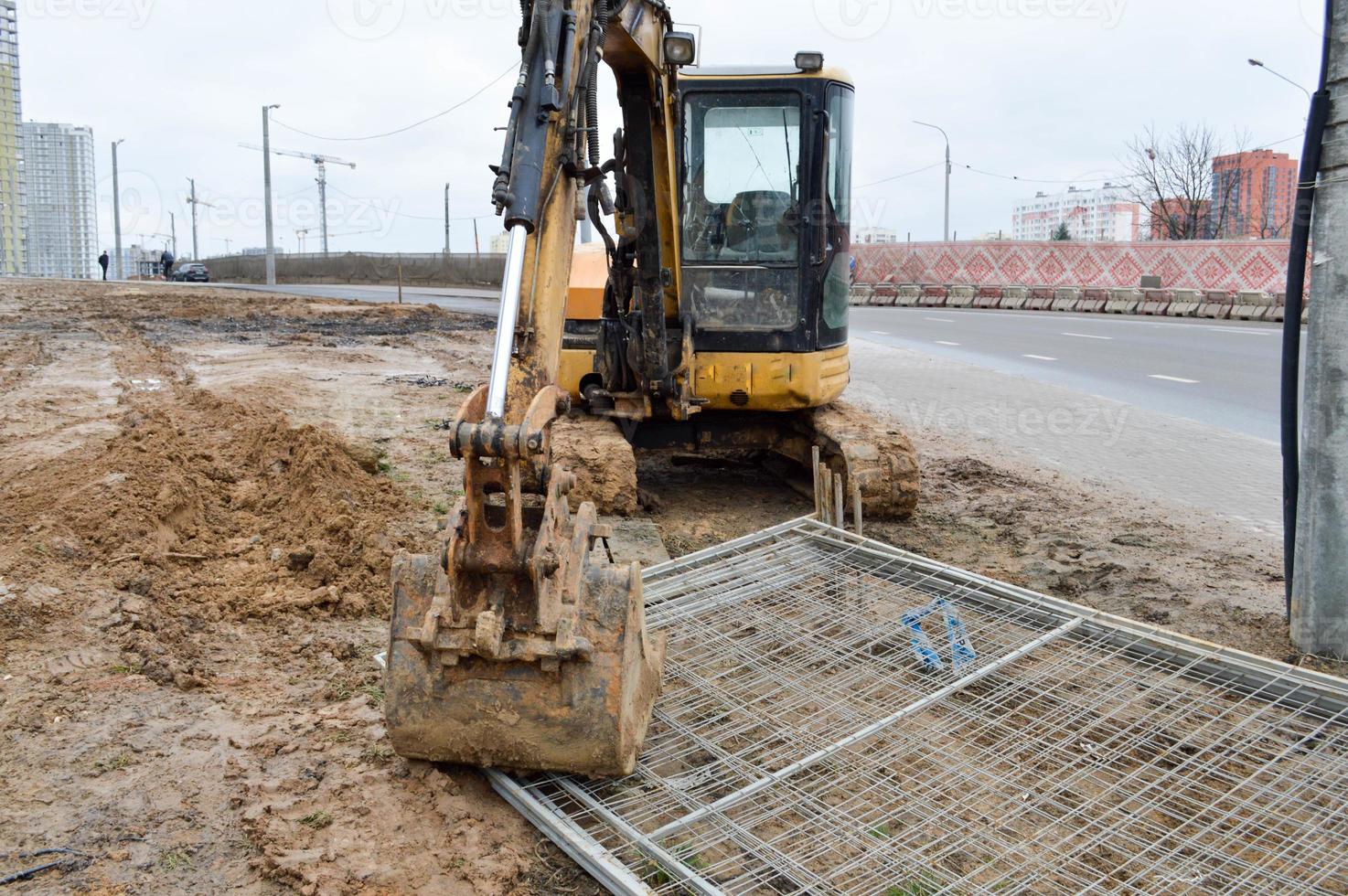 grande luminosa giallo potente industriale pesante scavatrice trattore, bulldozer, specializzato costruzione attrezzatura per strada riparazione durante il costruzione di un' nuovo micro-distretto nel un' grande città foto