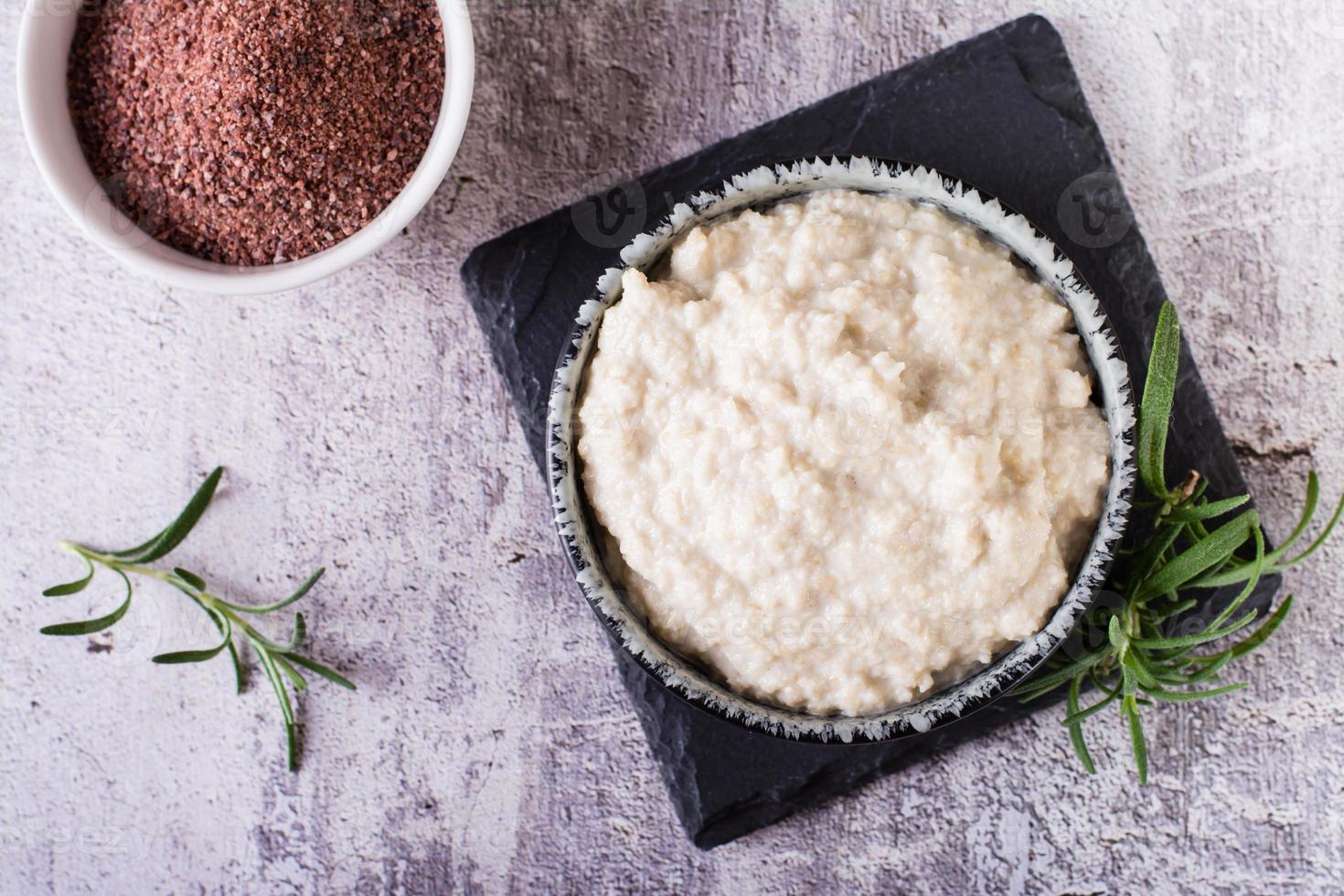 tahini salsa a partire dal sesamo semi nel un' ciotola e ingredienti per cucinando su il tavolo. superiore Visualizza. avvicinamento foto