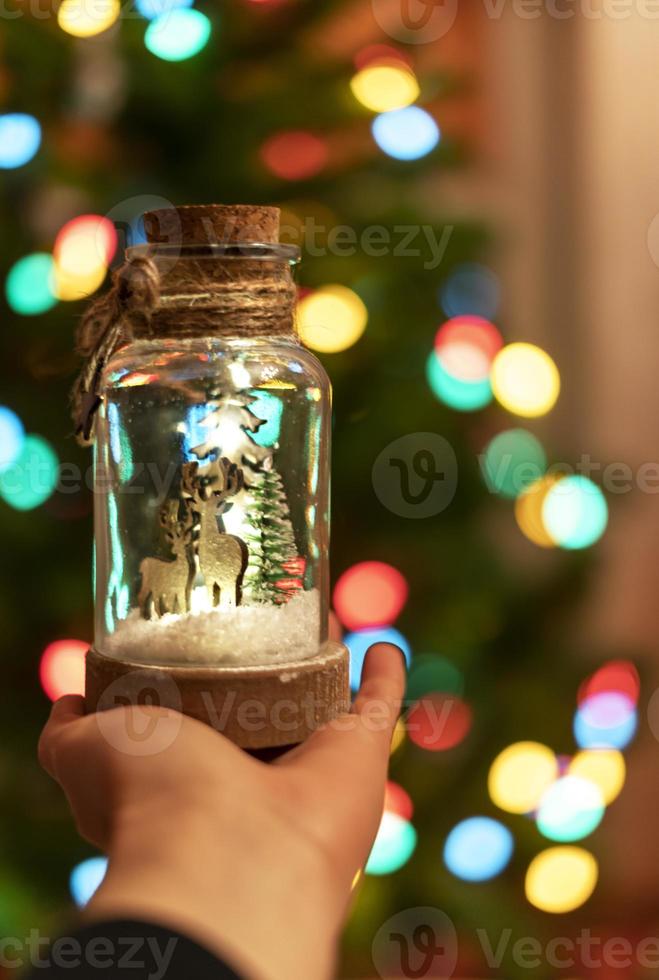 allegro Natale concetto festivo arredamento nel mano su sfondo di luci ghirlande di Natale albero decorazione nuovo anno vacanza presente foto