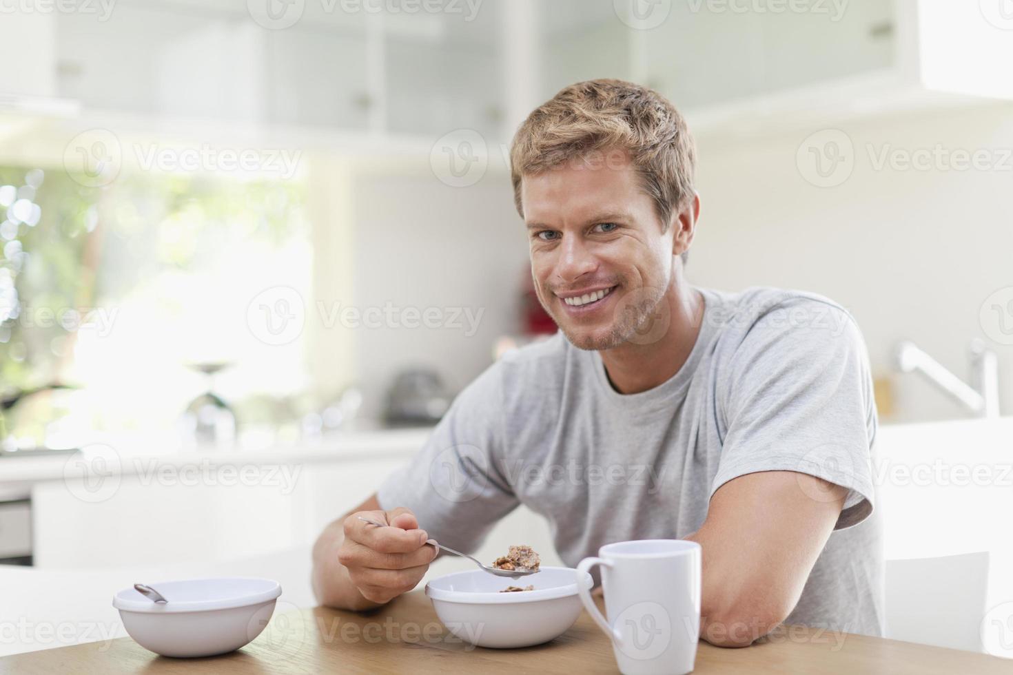 uomo che mangia colazione in cucina foto