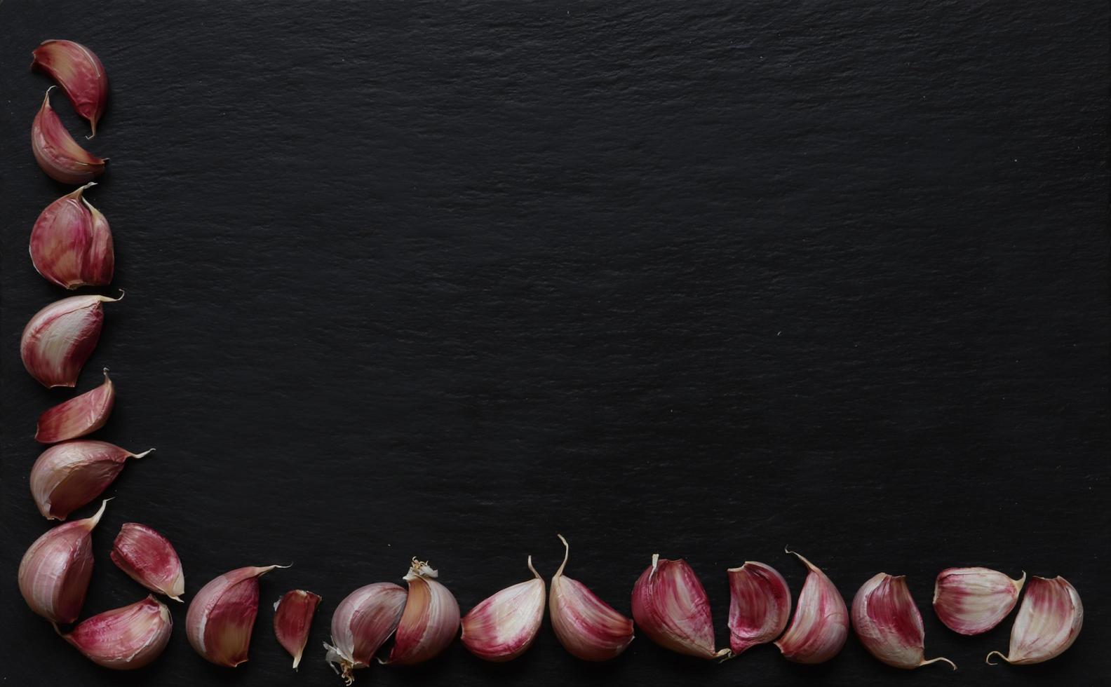 spicchi d'aglio su sfondo di ardesia foto