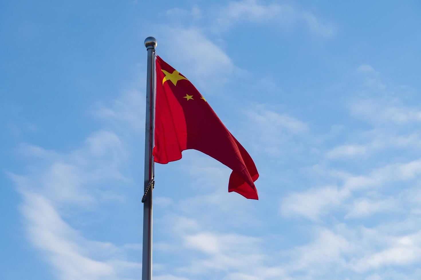bandiera cinese sul pennone contro il cielo blu foto