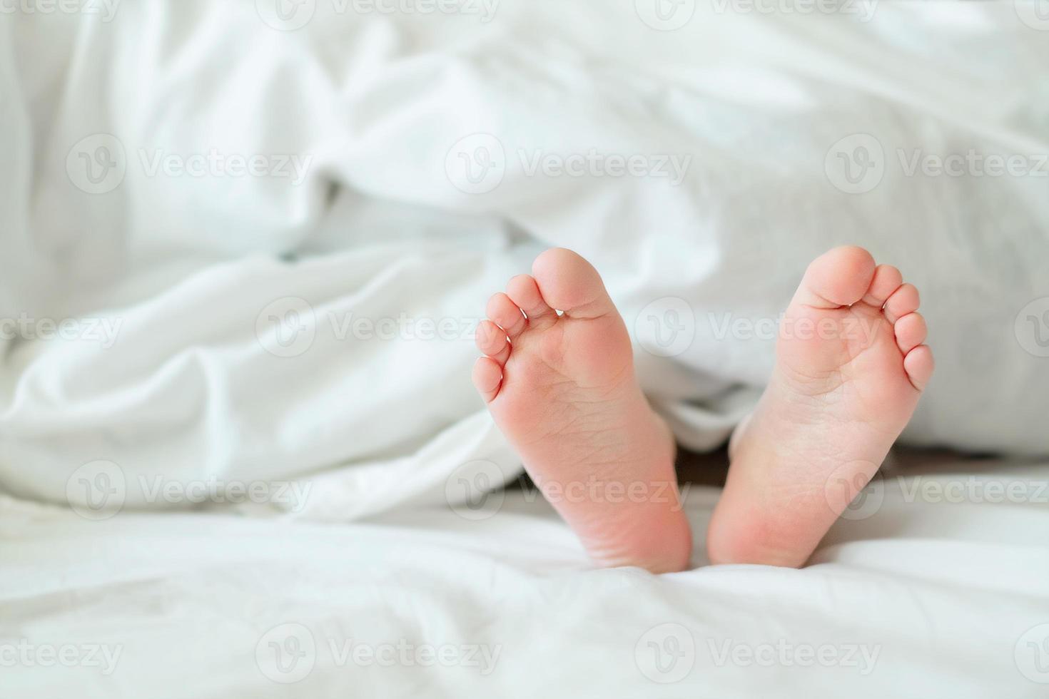 tacchi e dita su il letto. tacchi e piedi. figli di gambe. a piedi nudi su il letto. bambino gambe nel letto. foto