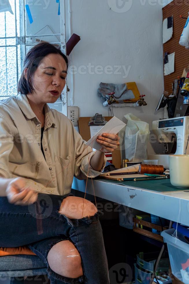 giovane latino donna, nel sua proprio pittura studio, crea dipinti diverso artistico tecniche foto