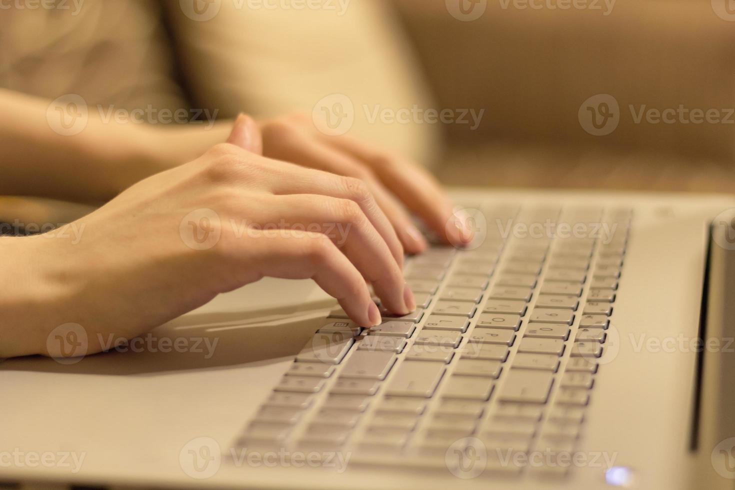 donna Lavorando a casa ufficio, mani su il computer portatile tastiera . vicino su foto