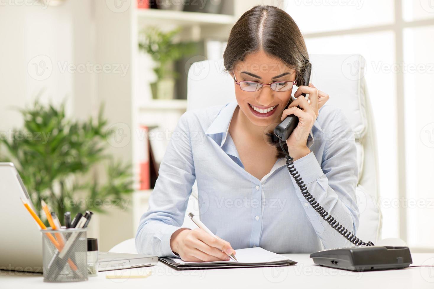imprenditrice telefonando in ufficio foto