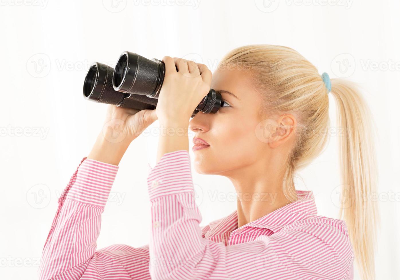 giovane donna guardare attraverso binocolo foto