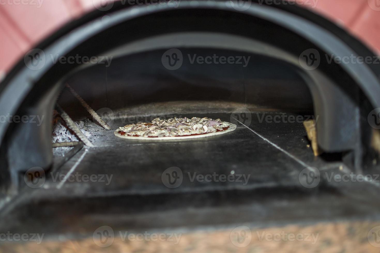 Pizza vicino il pietra stufa con fuoco. sfondo di un' tradizionale pizzeria ristorante con un' fuoco posto. foto