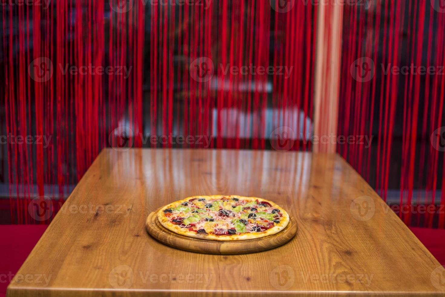 nero Pizza con pomodori, salsicce, Mozzarella e basilico. Impasto con salutare bambù carbone polvere foto