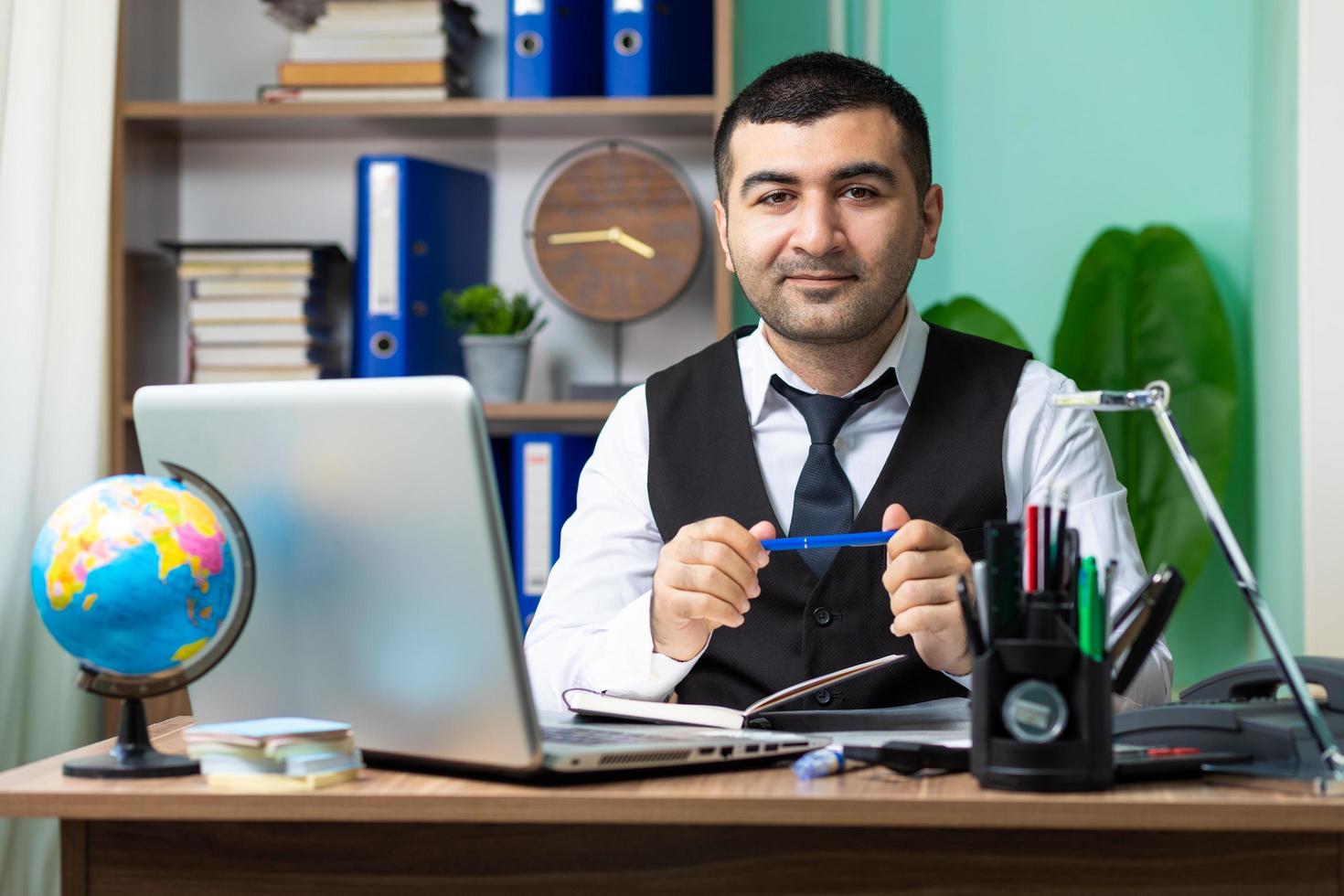 giovane uomo d'affari che tiene una penna in ufficio foto