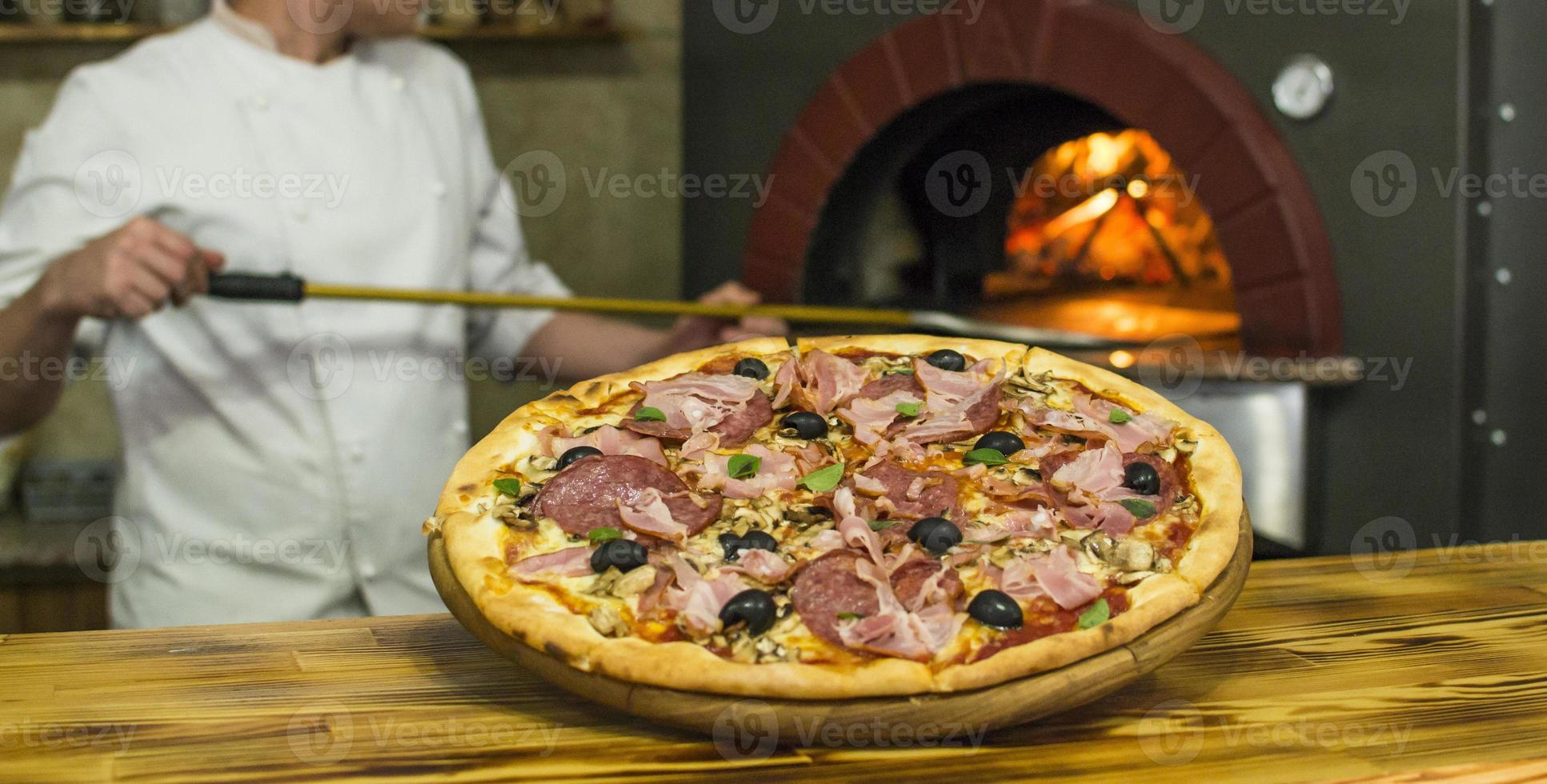 Pizza vicino il pietra stufa con fuoco. sfondo di un' tradizionale pizzeria ristorante con un' fuoco posto. foto