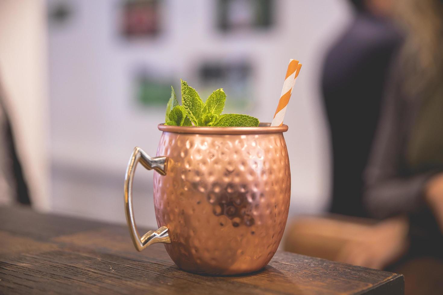 tazza da cocktail in rame sul tavolo di legno foto