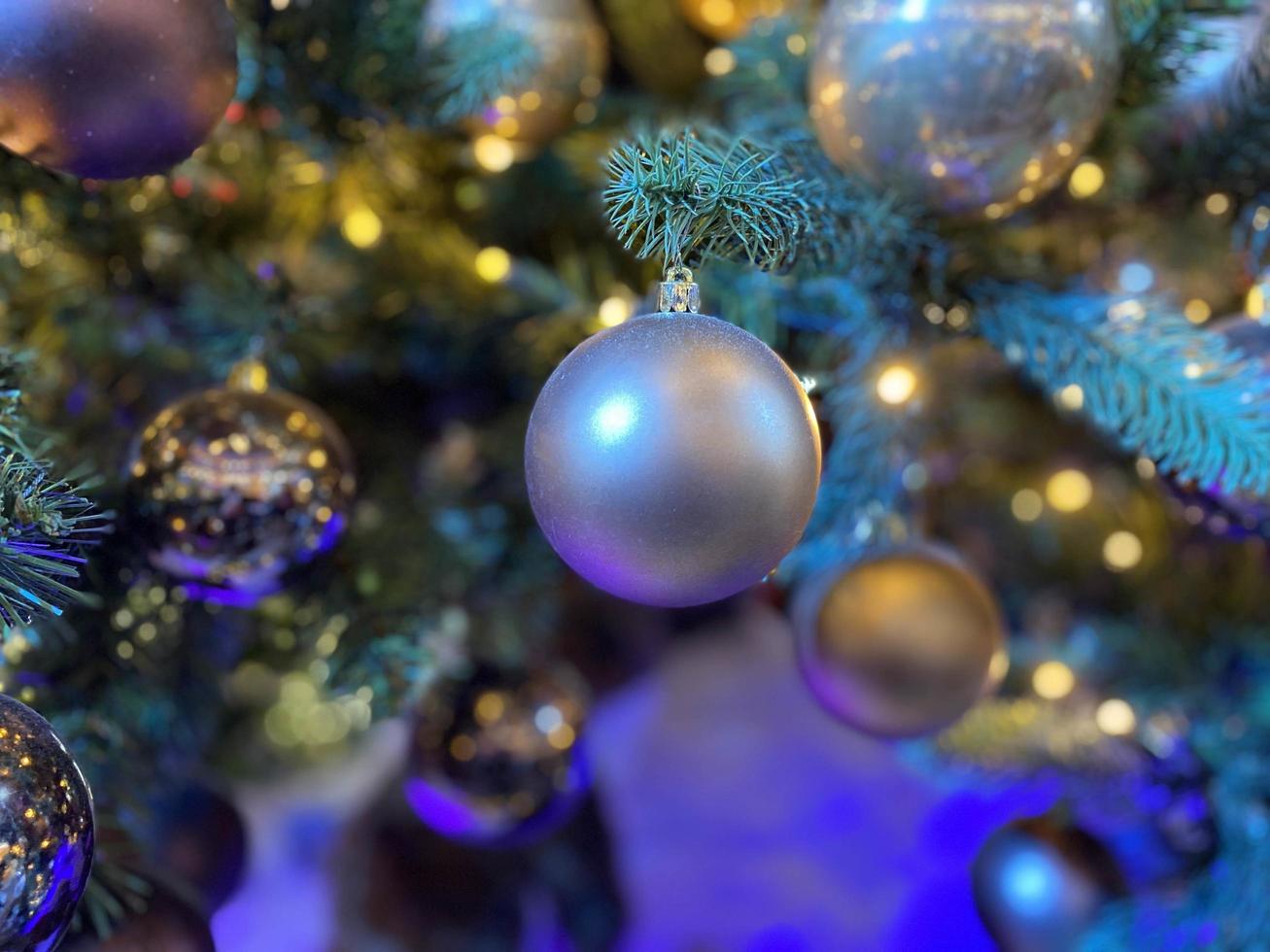 verde rami di un' soffice Natale festivo nuovo anno albero con giocattoli nel palle e luminosa raggiante leggero bulbi e ghirlande, sfondo foto