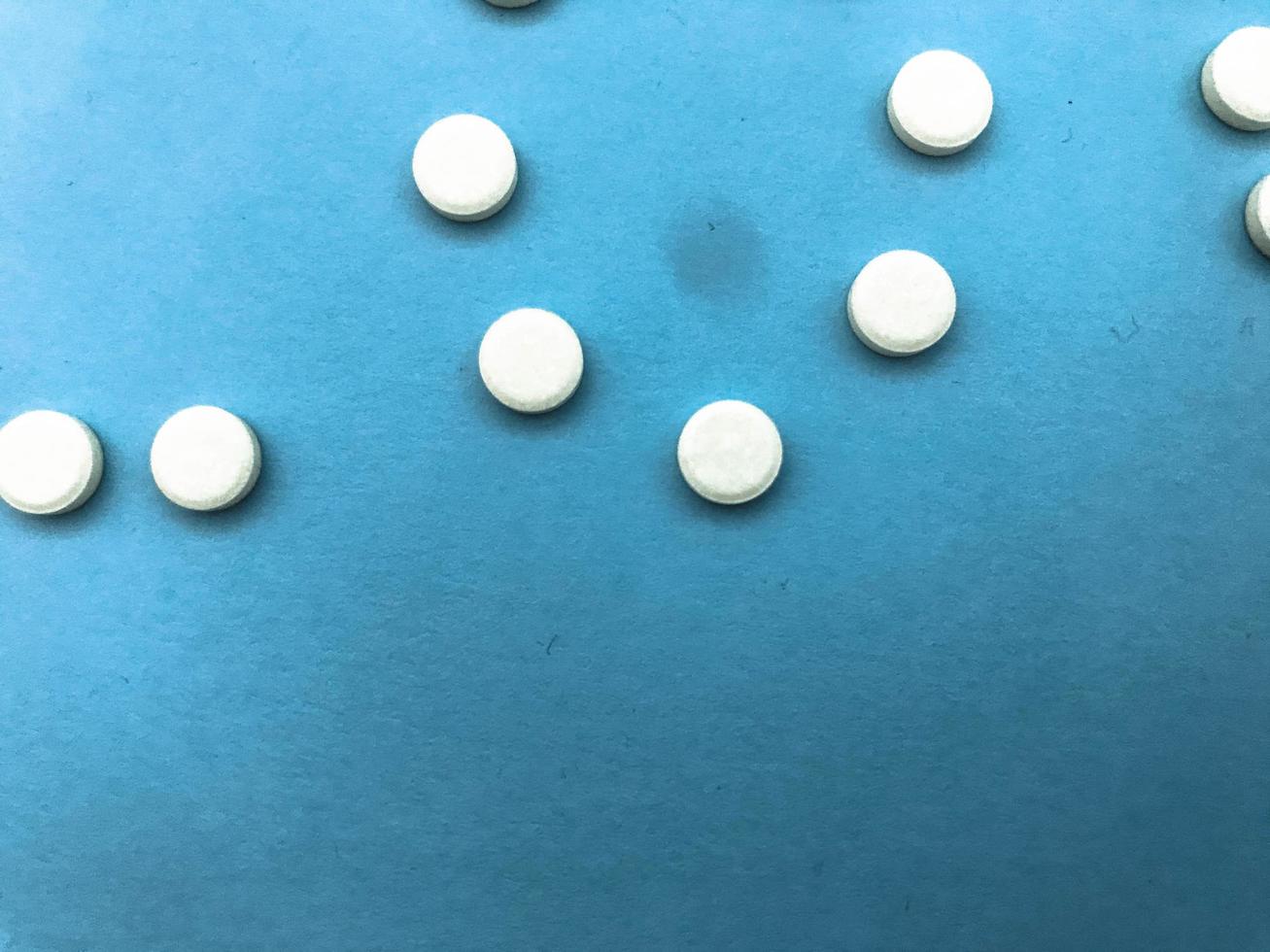 il giro medico farmaceutico medicinali per il trattamento di malattie e il uccisione di microbi e virus pillole e vitamine medicinali per coronavirus grigio su un' blu sfondo foto