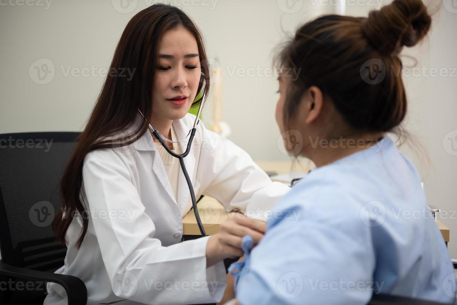 asiatico femmina medico cardiologo l'esame Grasso donna cardiaco paziente ascoltando controllo battito cardiaco utilizzando stetoscopio. foto