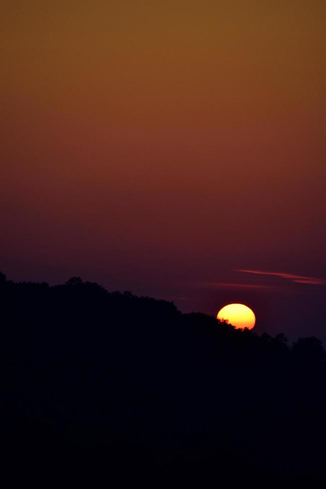 sole che tramonta sotto l'orizzonte foto