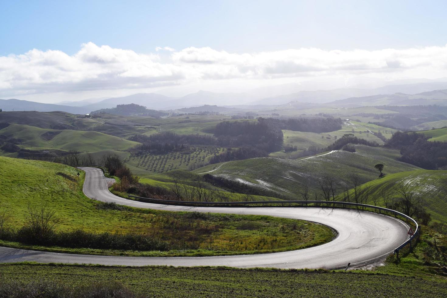 strada tortuosa attraverso il campo di erba verde foto