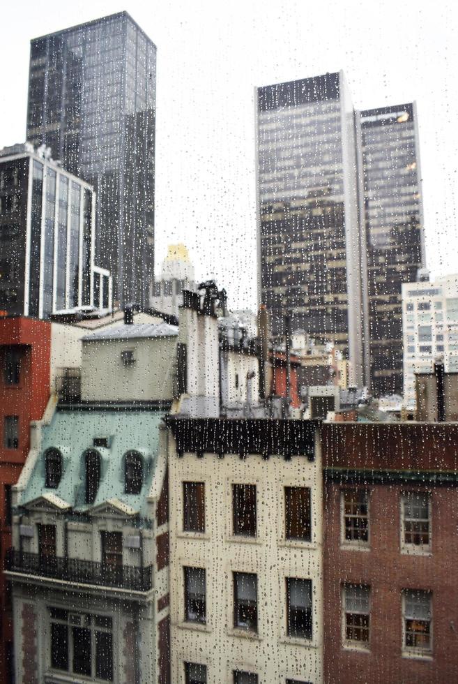 gocce di pioggia fuori dalla finestra di una città foto