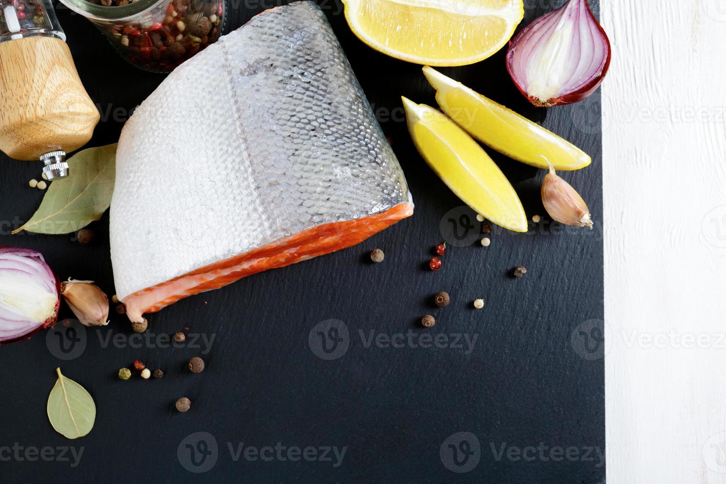 bistecca di salmone crudo su ardesia con limone e spezie foto