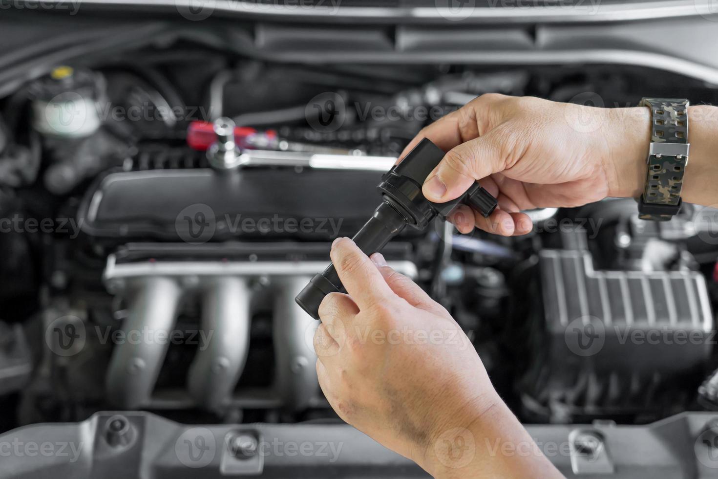 tecnico dai un'occhiata vecchio scintilla spina bobina con bruciare votazione su motore bobina nel Manutenzione servizio di benzina motore nel box auto foto