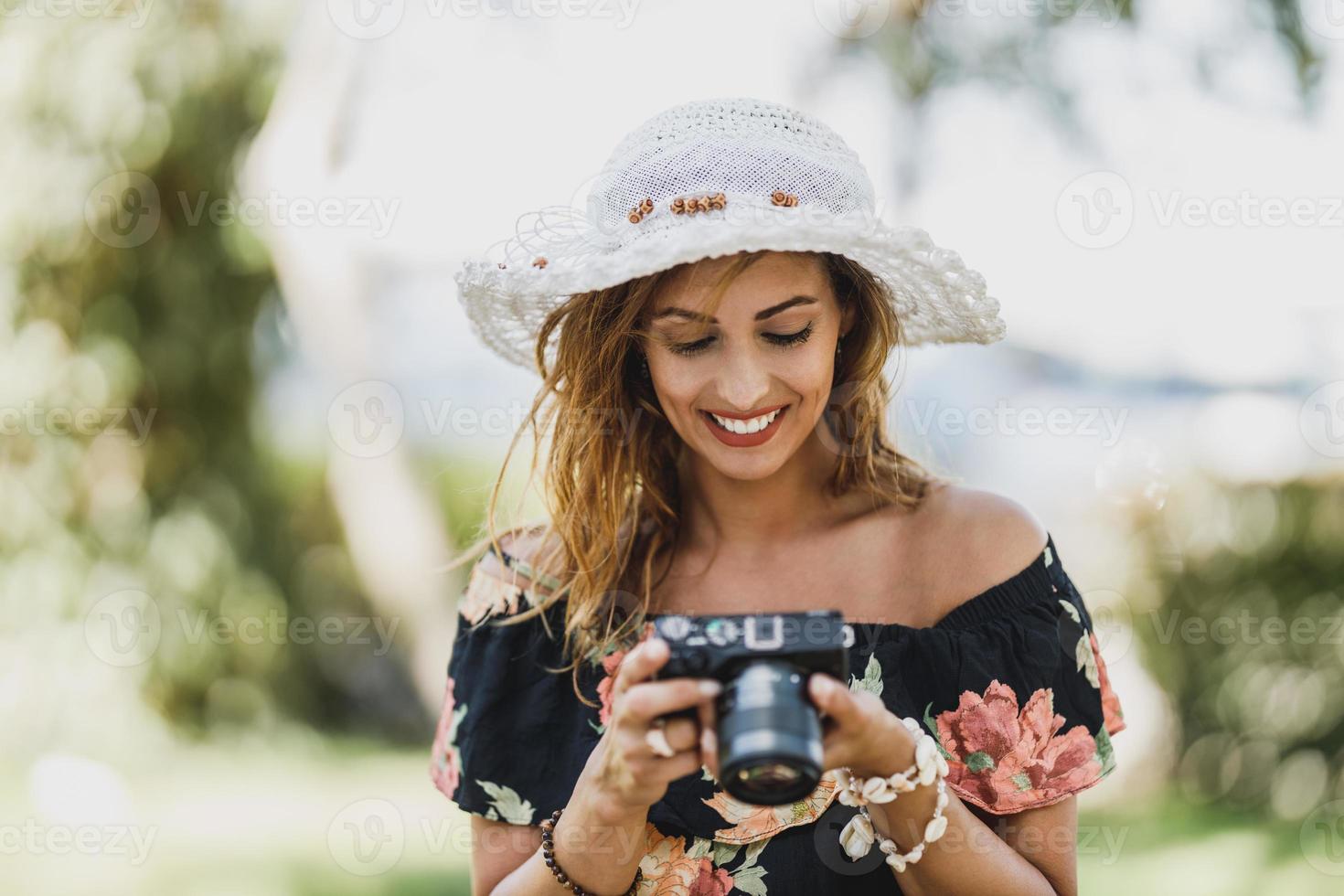 donna utilizzando digitale telecamera mentre godendo estate vacanza foto