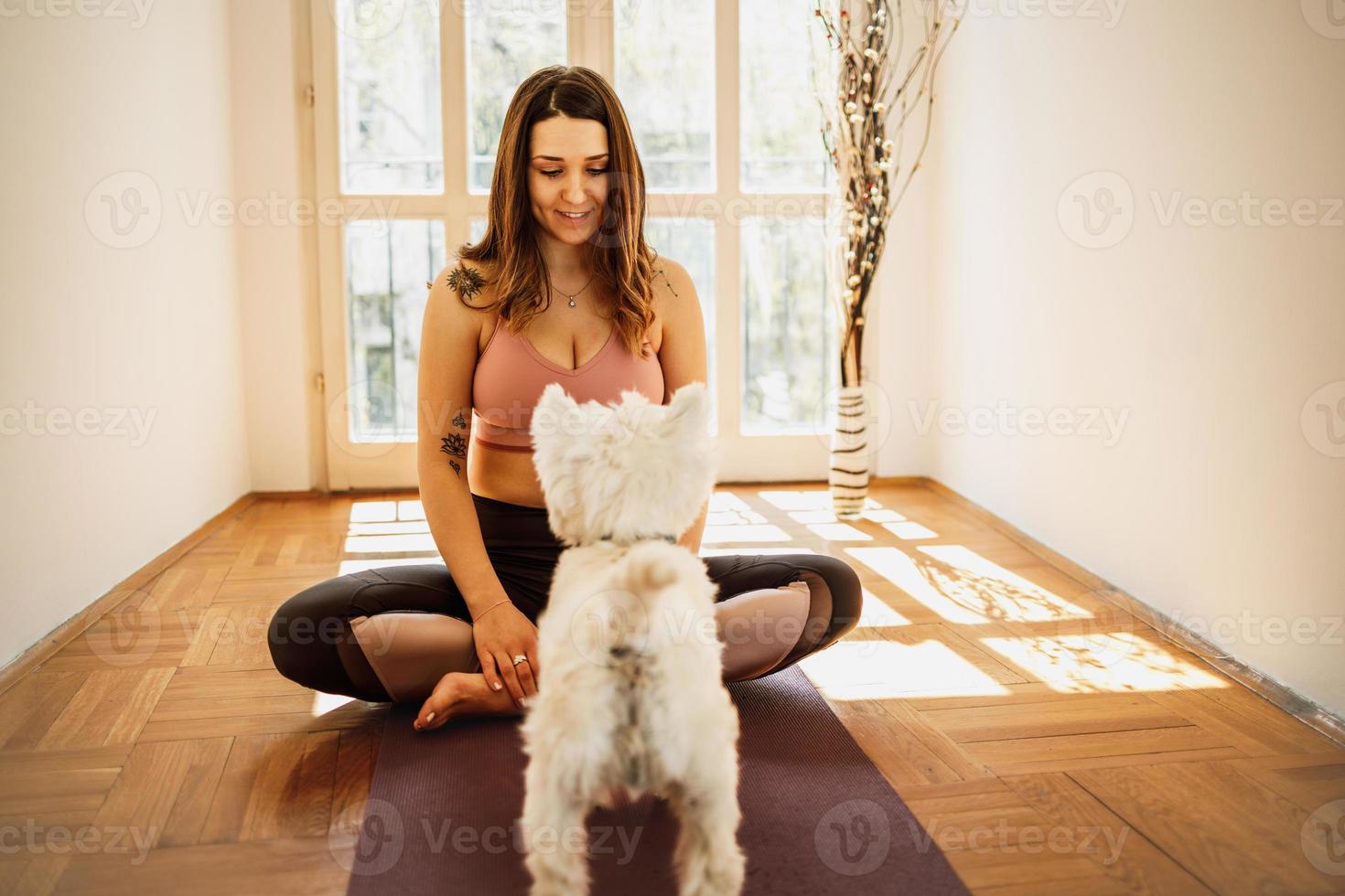 donna fare yoga con sua cane foto