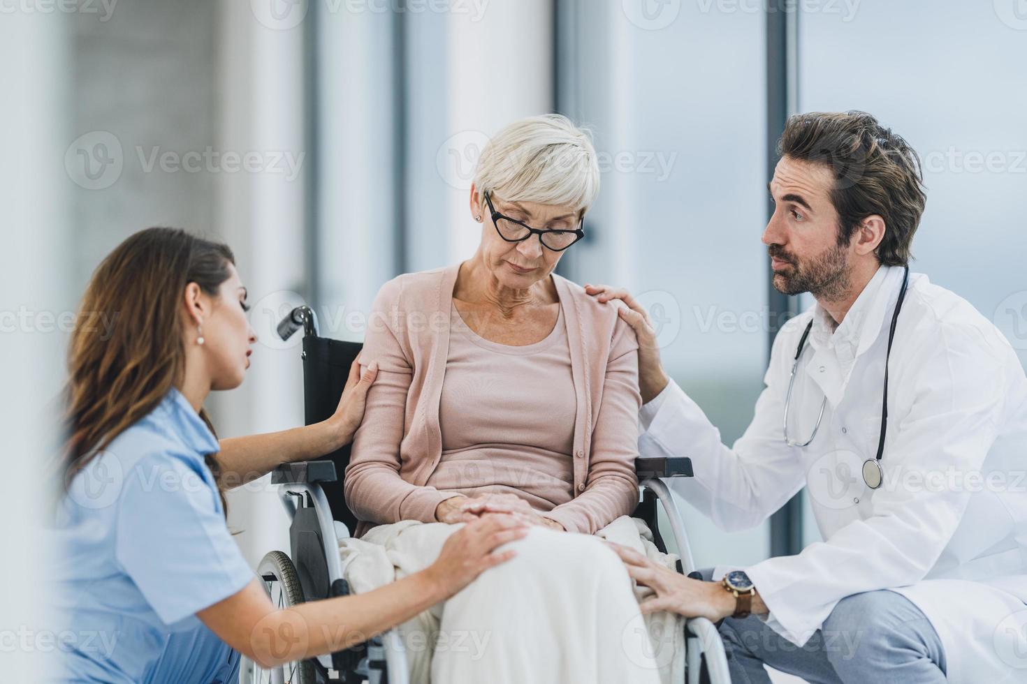 medico e infermiera parlando con loro anziano femmina in sedia a rotelle paziente a il ospedale foto