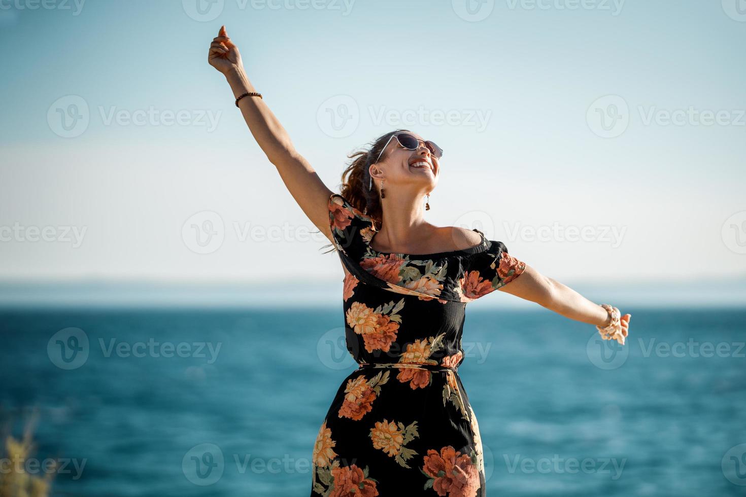 sorridente donna nel fiore vestito è avendo divertimento a il estate giorno foto