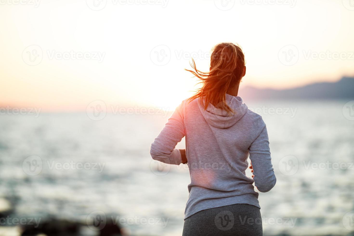 donna jogging vicino il mare spiaggia foto