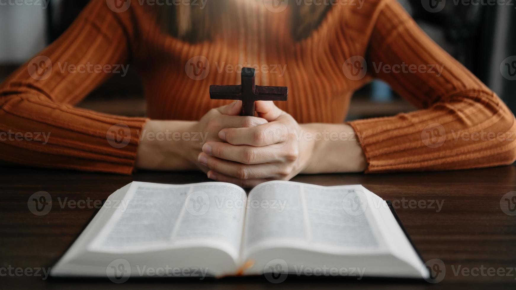 donna seduta e studiando il scritture.il di legno attraversare nel il mani. cristiano formazione scolastica concetti il santo scritture Aperto foto