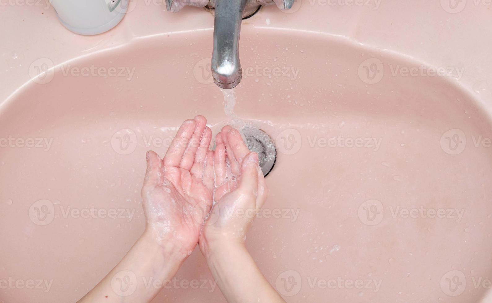 lavaggio mani con sapone nel bagno foto