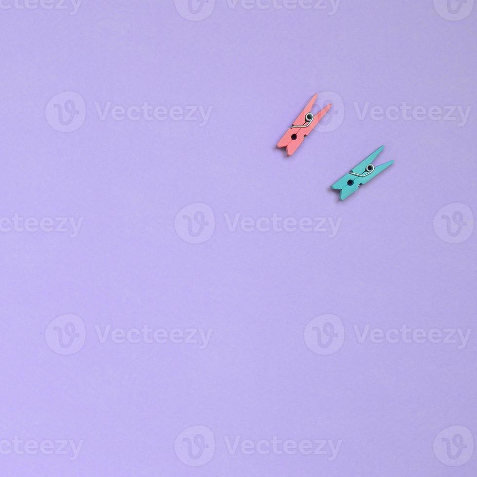 Due colorato di legno pioli menzogna su struttura sfondo di moda pastello viola colore carta nel minimo concetto foto