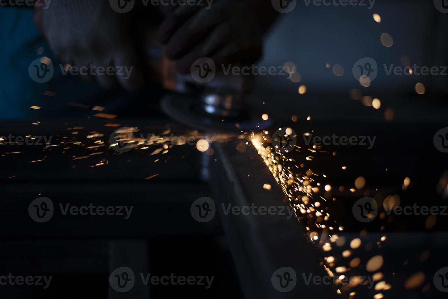 scintille nel scuro. metallo macinazione. arancia luci volare nel diverso indicazioni. opera nel metallo officina. foto