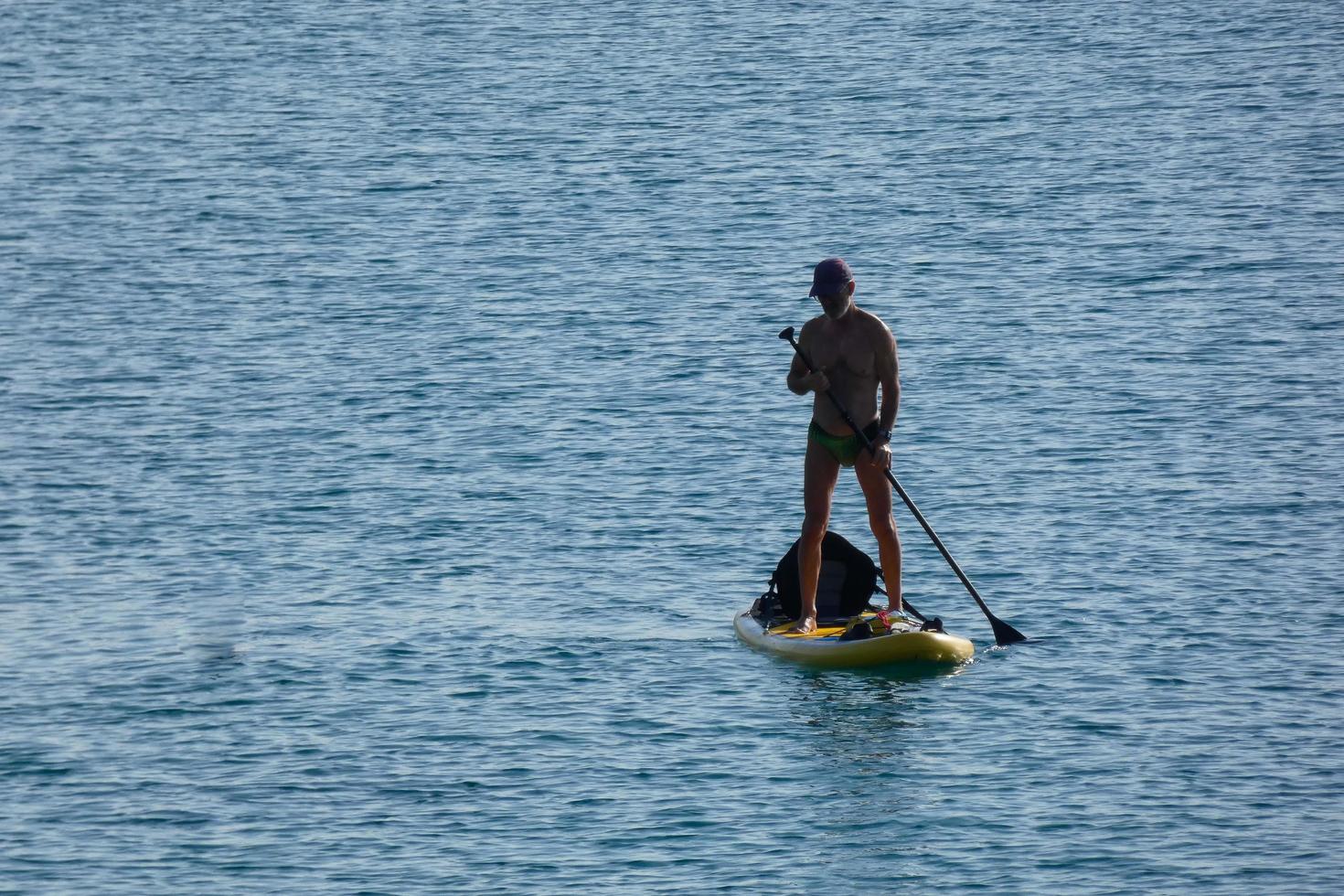 nuotatore su vacanza pagaia fare surf nel il mediterraneo mare foto