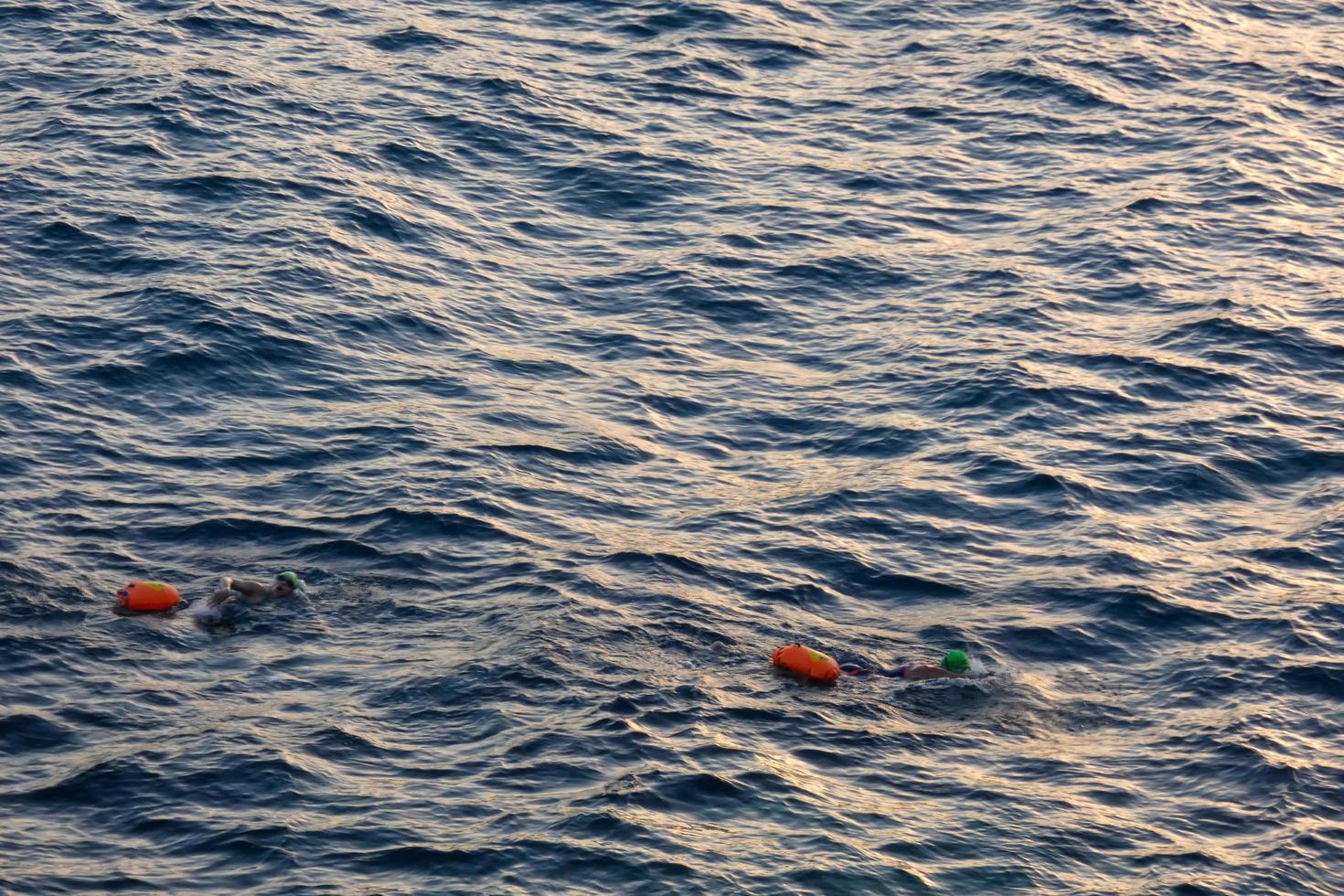 nuotatore nuoto nel Aperto acqua nel il mediterraneo mare con un' sicurezza boa foto