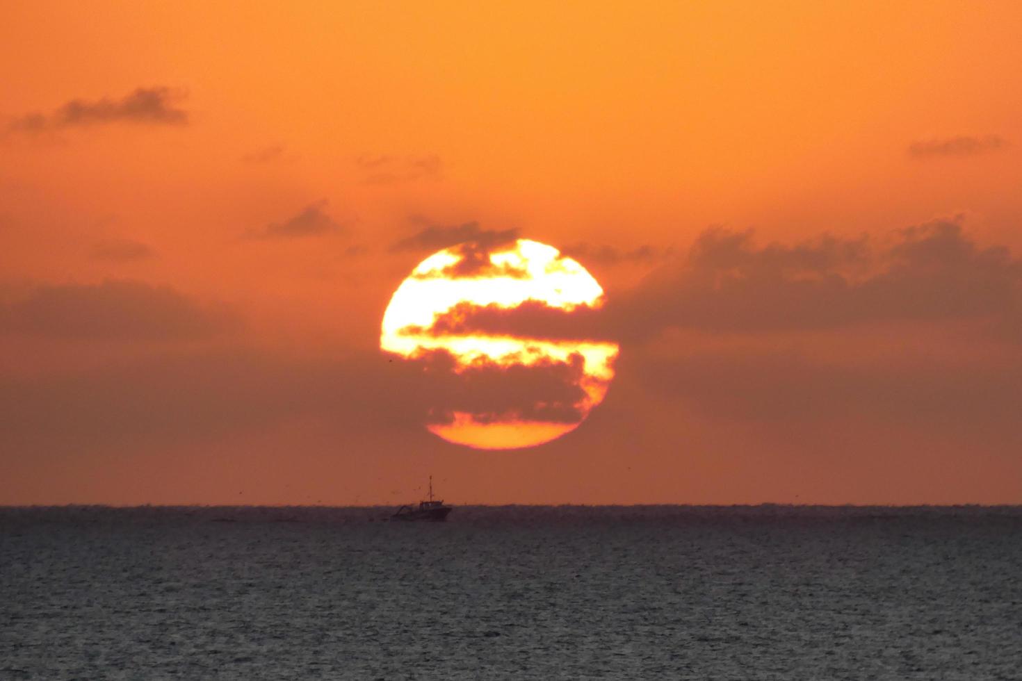 sole disco crescente al di sopra di il orizzonte di il mare, Alba, alba foto