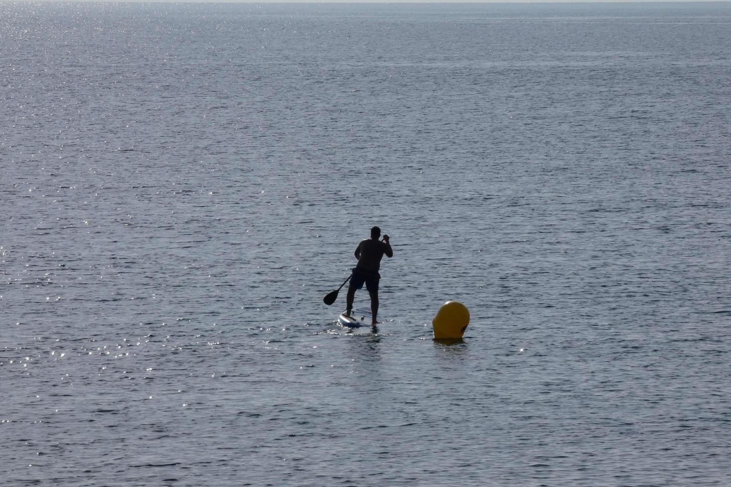nuotatore su vacanza pagaia fare surf nel il mediterraneo mare foto