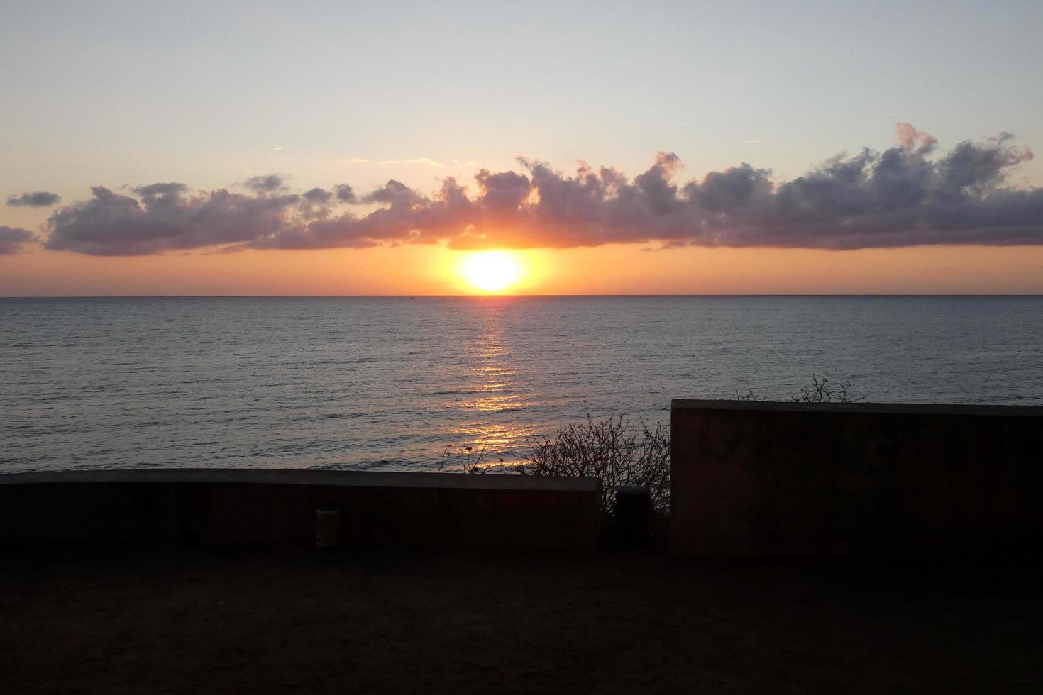 sole disco crescente al di sopra di il orizzonte di il mare, Alba, alba foto