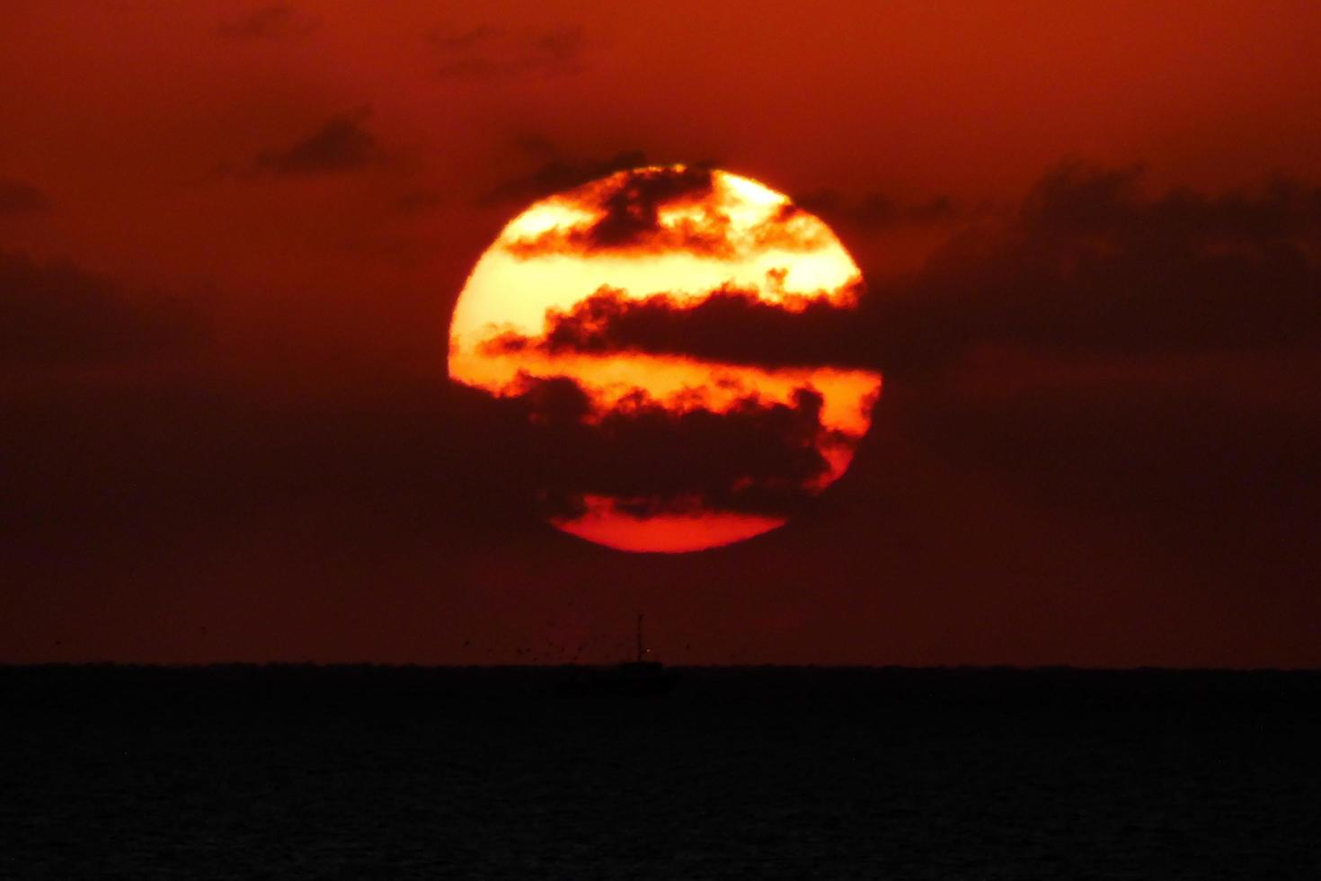 sole disco crescente al di sopra di il orizzonte di il mare, Alba, alba foto