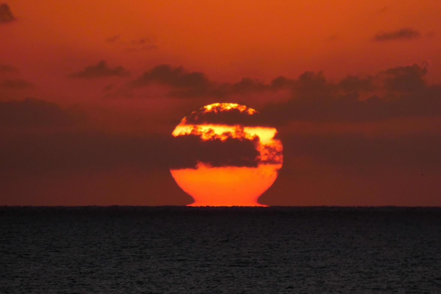 sole disco crescente al di sopra di il orizzonte di il mare, Alba, alba foto