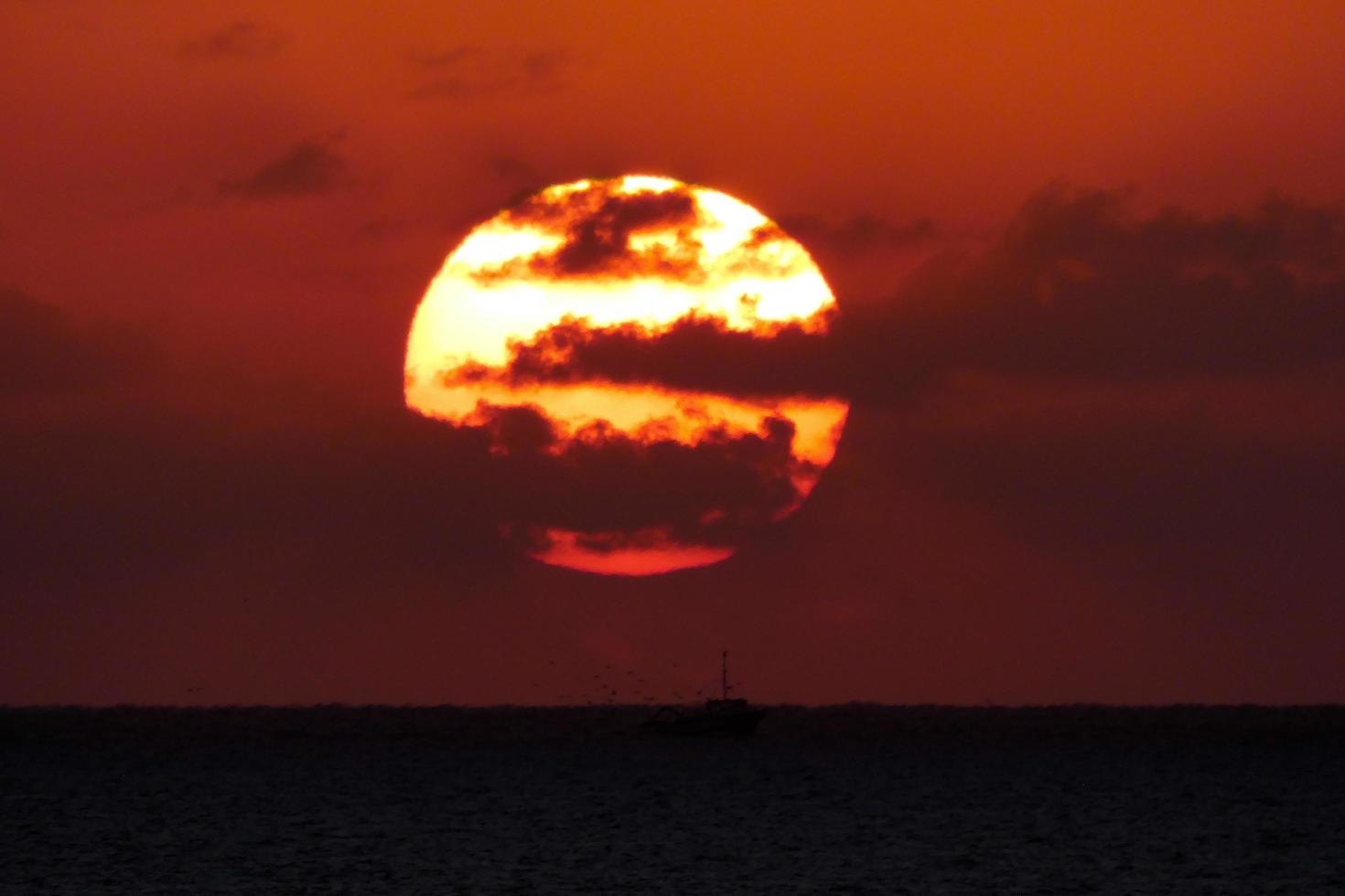 sole disco crescente al di sopra di il orizzonte di il mare, Alba, alba foto