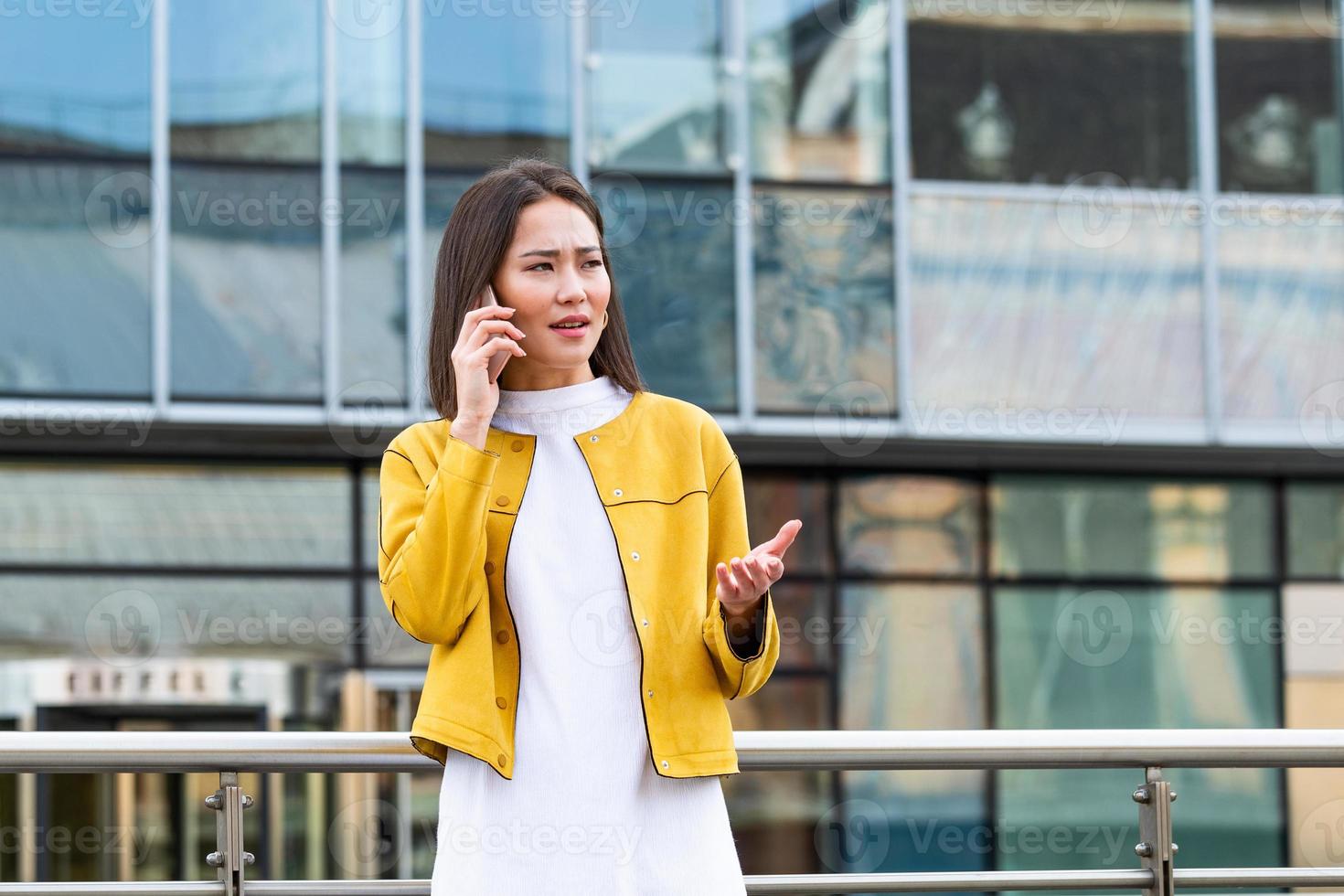 asiatico donna d'affari nel formale indossare avendo guaio con contratti parlando su il Telefono. donna d'affari arrabbiato circa di lavoro d'ufficio fallimento a posto di lavoro, dirigenti avendo conflitto foto