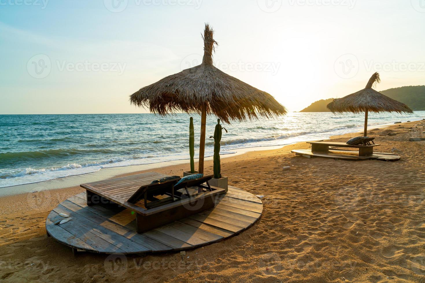 sedia a sdraio e ombrellone con sfondo spiaggia mare foto