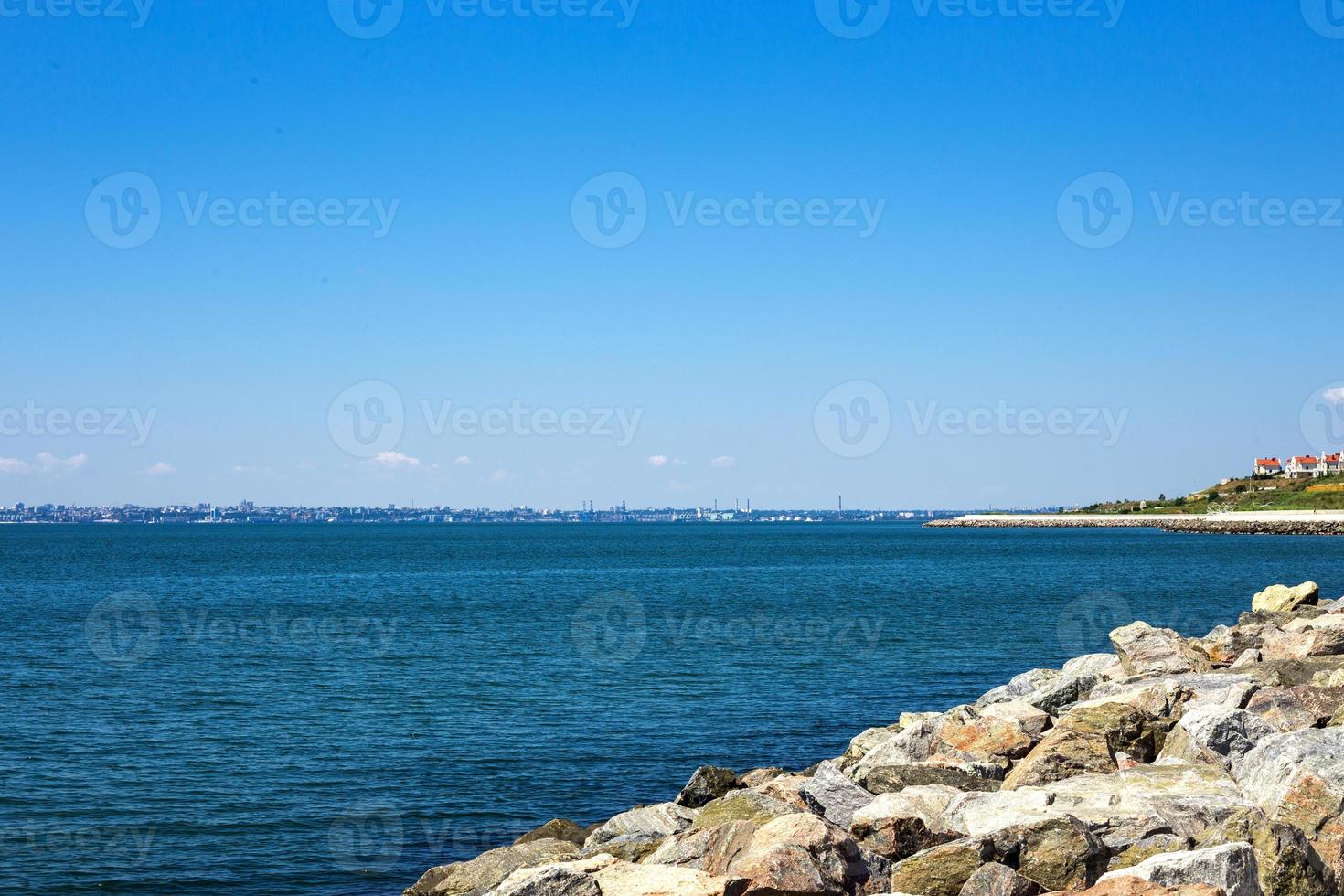 bianca pietre spiaggia, rocciosa spiaggia con un' blu cielo e chiaro acqua di il oceano foto