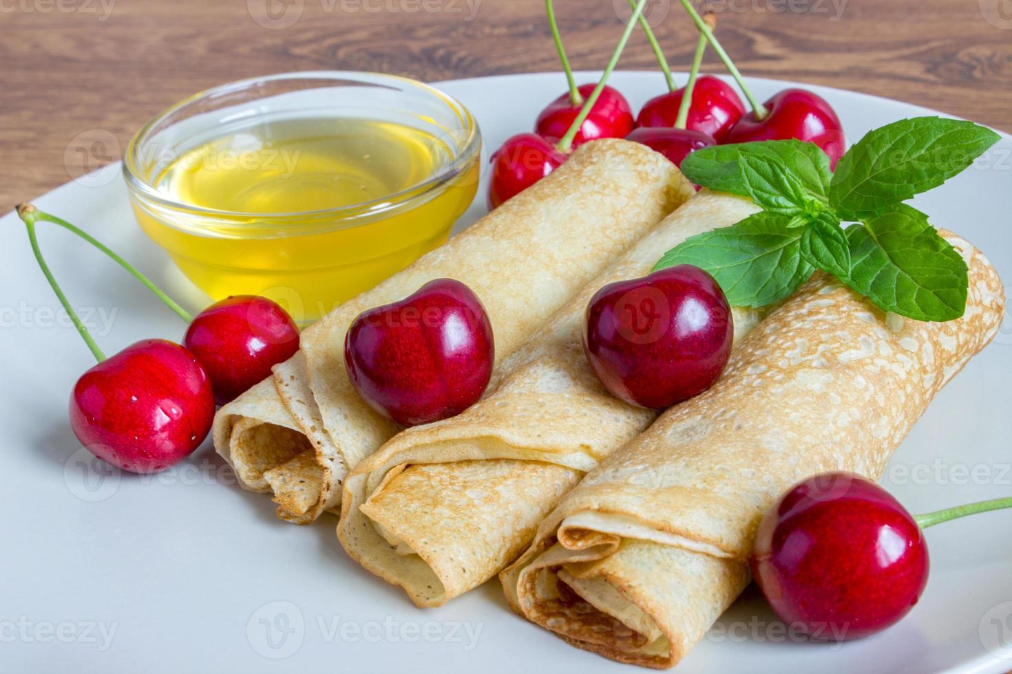 fatti in casa dolce. fritte Pancakes con Miele. crespo con ciliegia su bianca piatto sfondo. foto