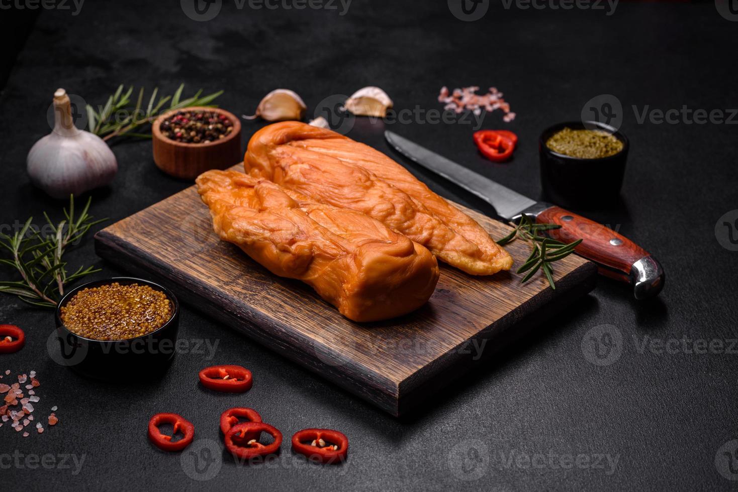 gustoso affumicato filetto di pollo Seno con spezie e erbe aromatiche su un' di legno taglio tavola foto