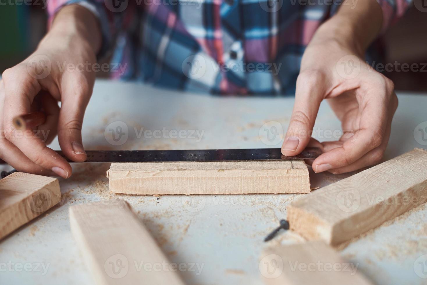 falegname mani assunzione misurazione con un' matita di di legno tavola. foto