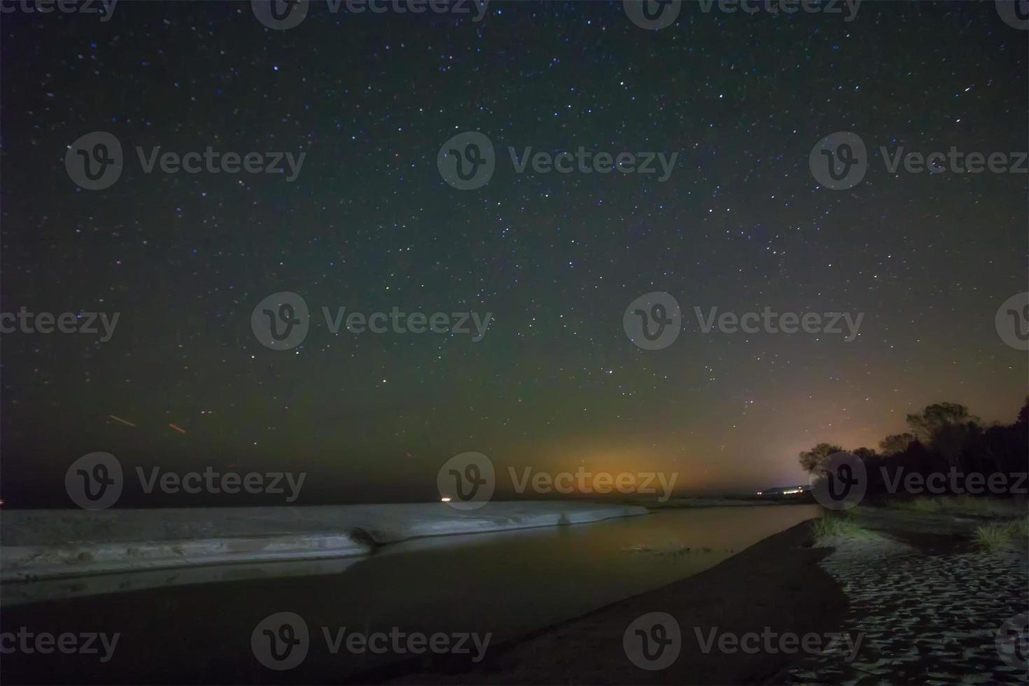 notte cielo con stelle e sabbia spiaggia foto