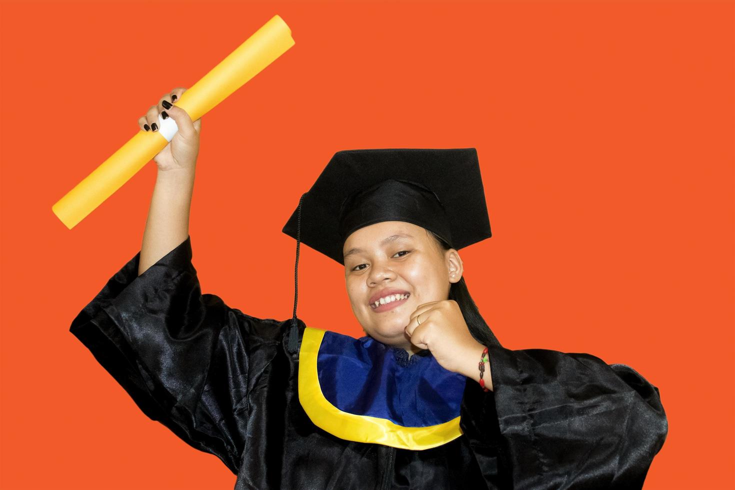 ritratto di contento e eccitato asiatico alunno ragazza nel la laurea berretto, studiando, formazione scolastica, Università, Università, diplomato concetto. arancia bandiera foto